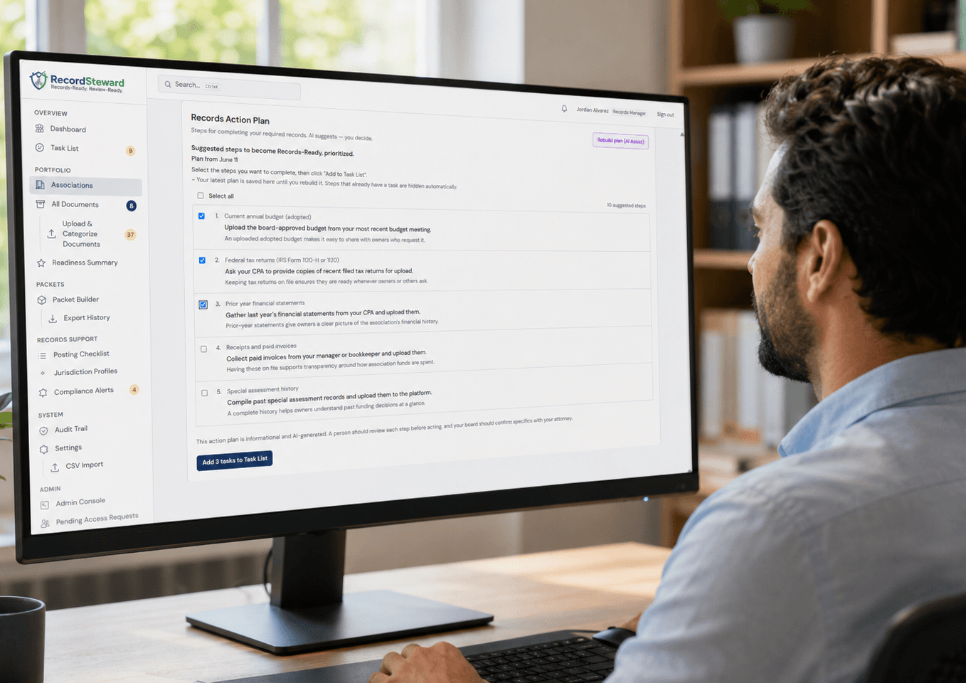 A records manager at his desk viewing the RecordSteward Records Action Plan on his monitor — a prioritized list of AI-suggested steps for an example condo association to become Records-Ready.