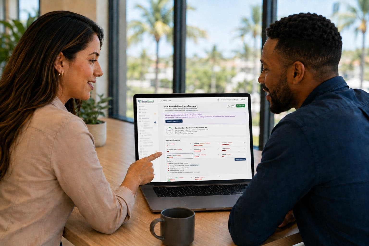 Two CAM managers reviewing an association's Records Readiness Summary together in RecordSteward on a laptop.
