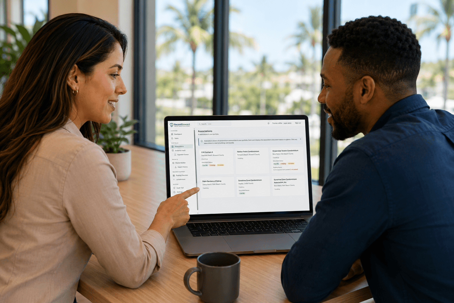 Two CAM managers reviewing association records together on a RecordSteward dashboard.